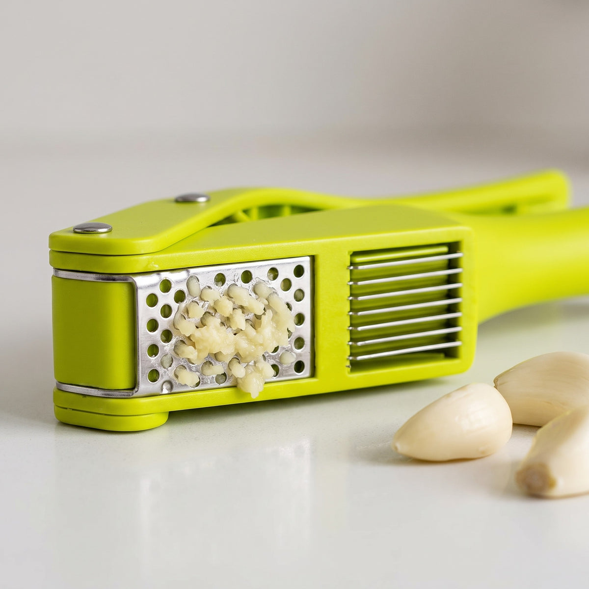 2-in-1 Garlic Press and Slicer with Squeeze Handles - close-up of the stainless steel press plate and slicing grid