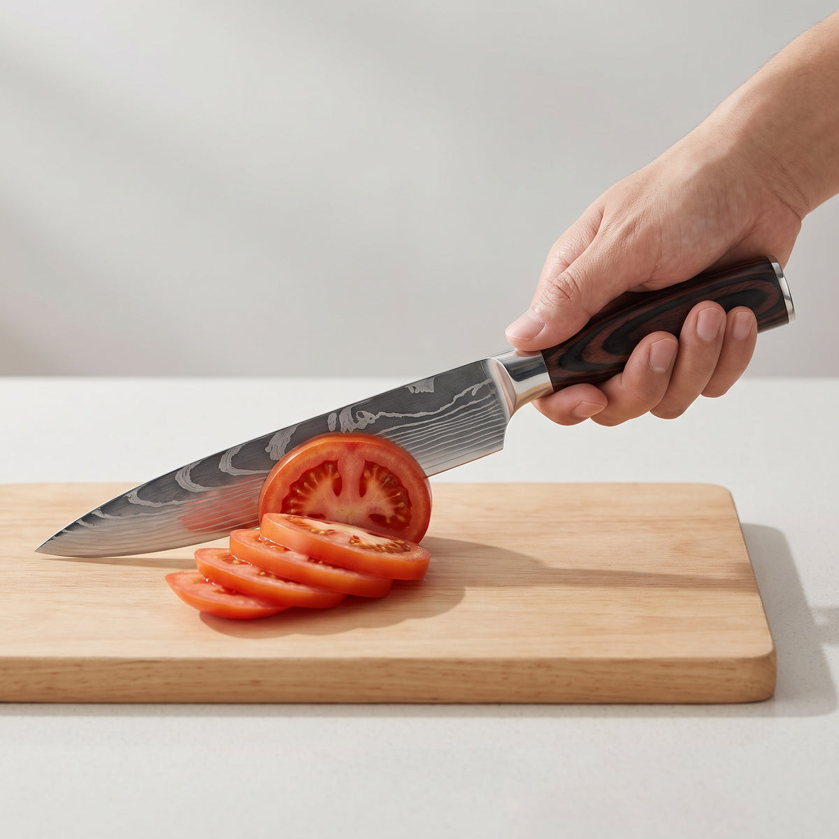 3-Piece Damascus Pattern Kitchen Knife Set with Non-Slip Handles in use, slicing a tomato with the Damascus chef knife