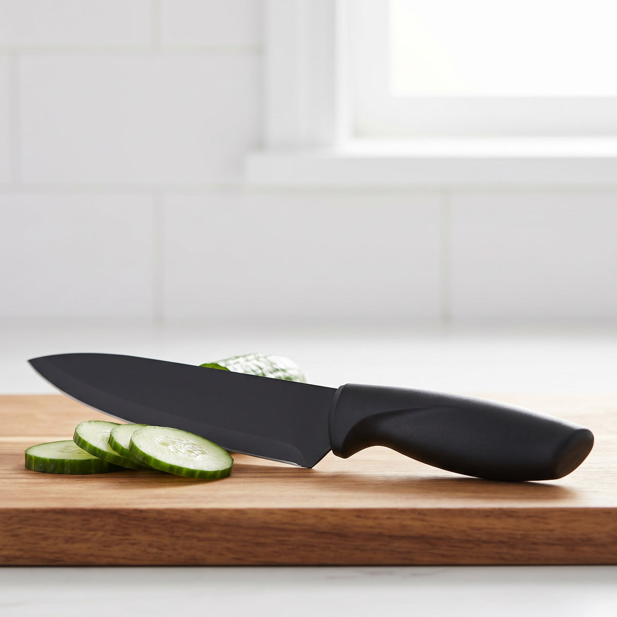 7-Piece Non-Stick Black Knife Set with Sharpener and Acrylic Stand - close-up of the black non-stick coated chef knife blade and matte black handle