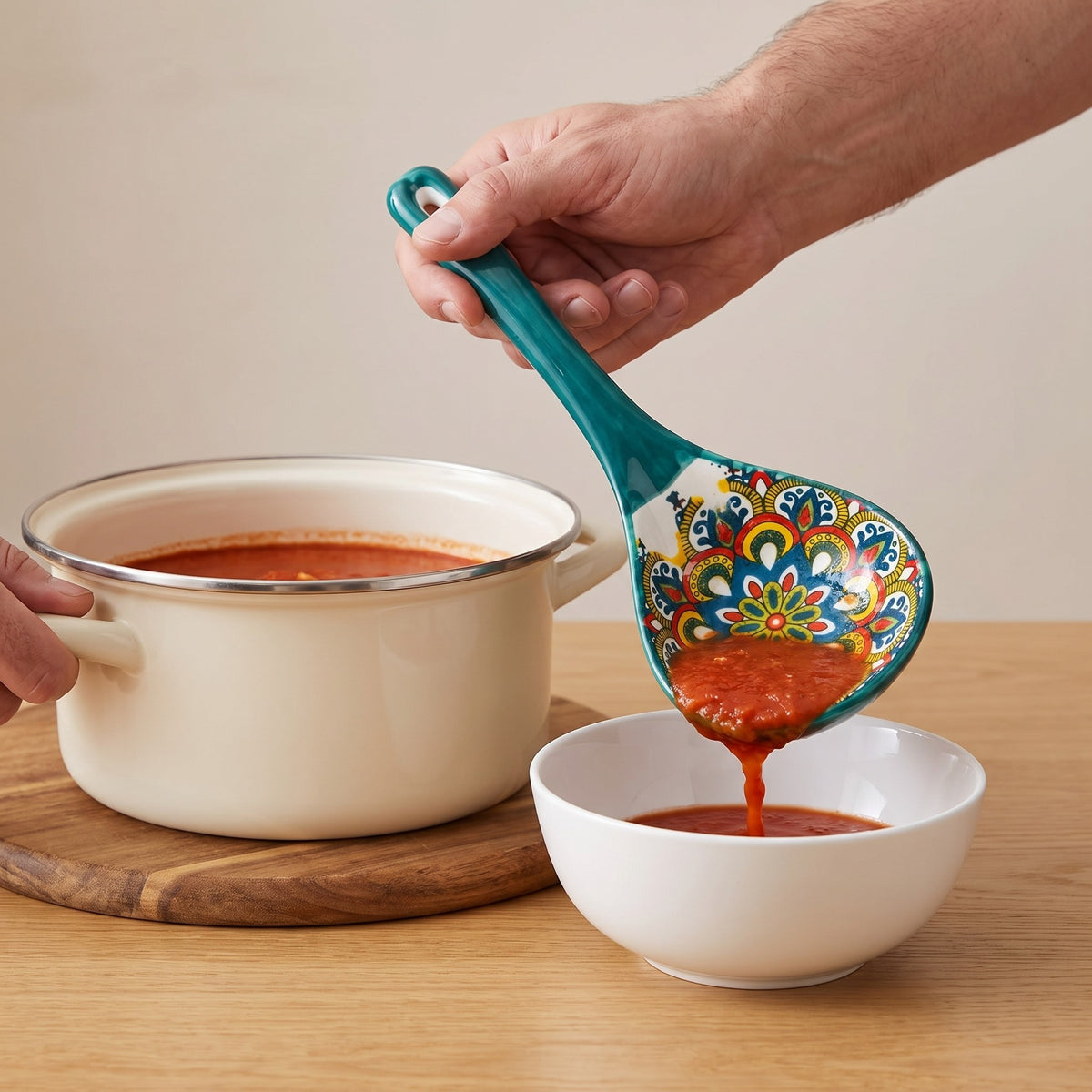 Boho Patterned Ceramic Soup Ladle with Large Scoop in use, serving tomato soup into a bowl