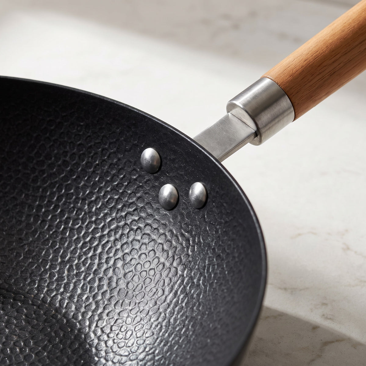 Cast Aluminum Non-Stick Wok with Wooden Handle - close-up of the textured non-stick surface, riveted bracket and wood handle