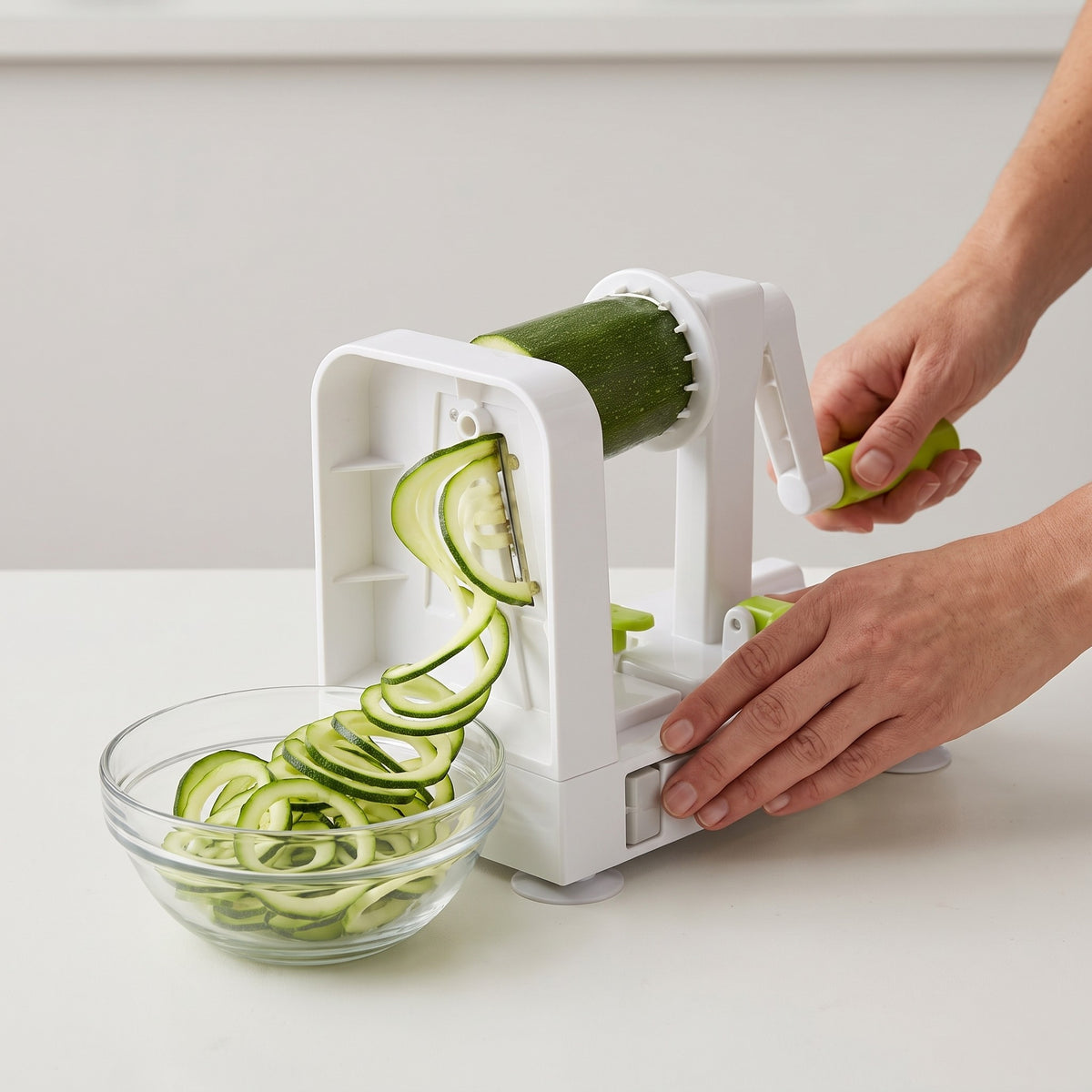 Countertop Hand-Crank Vegetable Spiralizer with Suction Cups in use, cranking zucchini into noodles