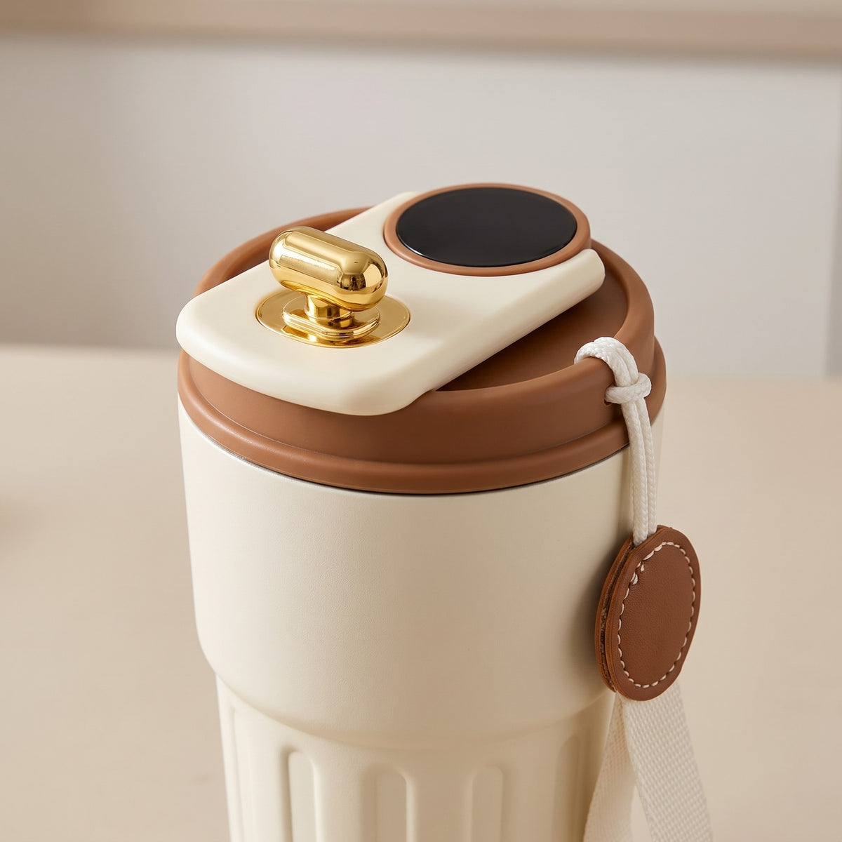 Double-Wall Insulated Tumbler with LCD Temperature Display - close-up of the lid, gold flip button and leather charm