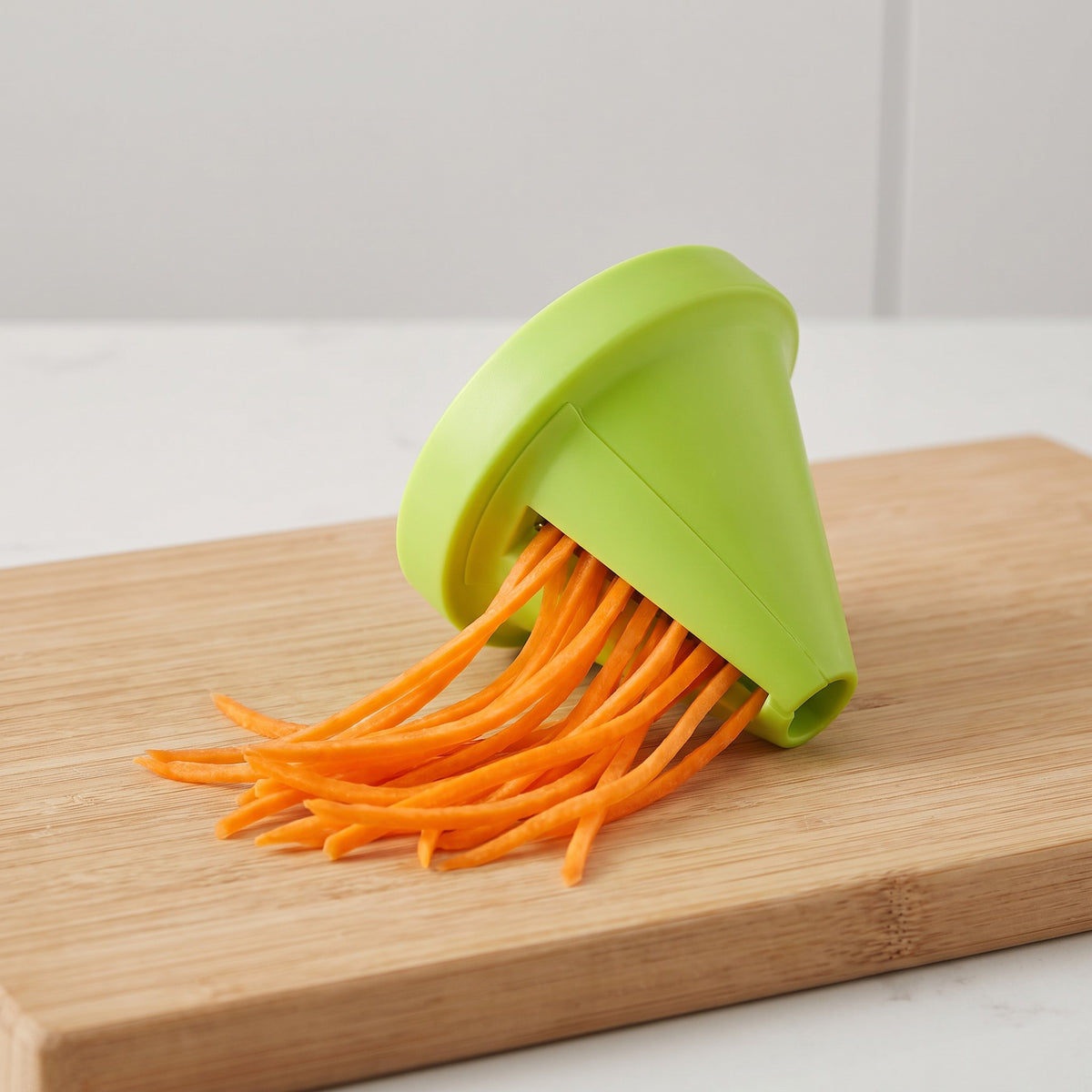 Handheld Vegetable Spiralizer with Conical Blade - close-up of the lime-green cone and fresh carrot noodles