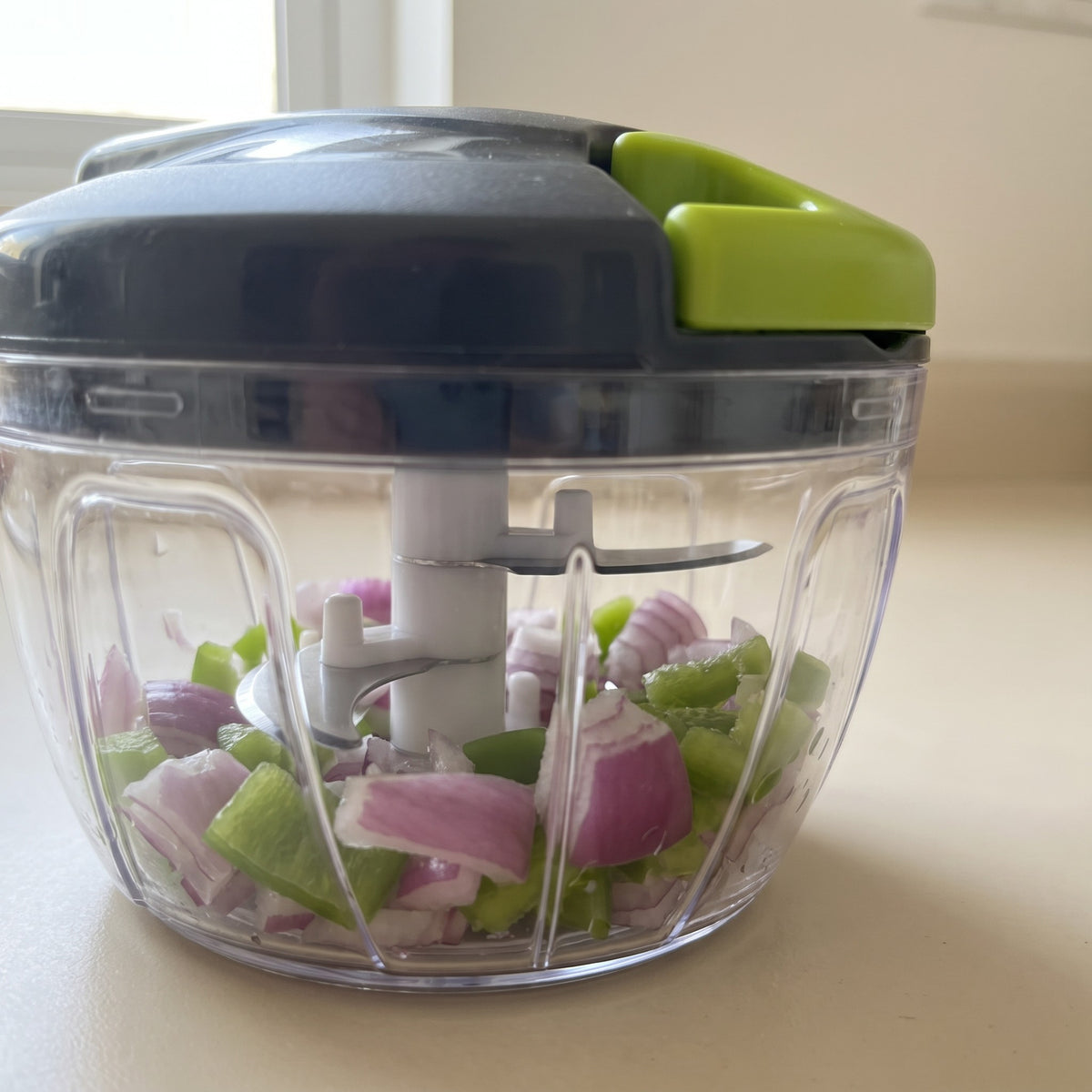 Manual Pull-Cord Food Chopper with Stainless Steel Blades - close-up of the stainless steel blades in the clear bowl