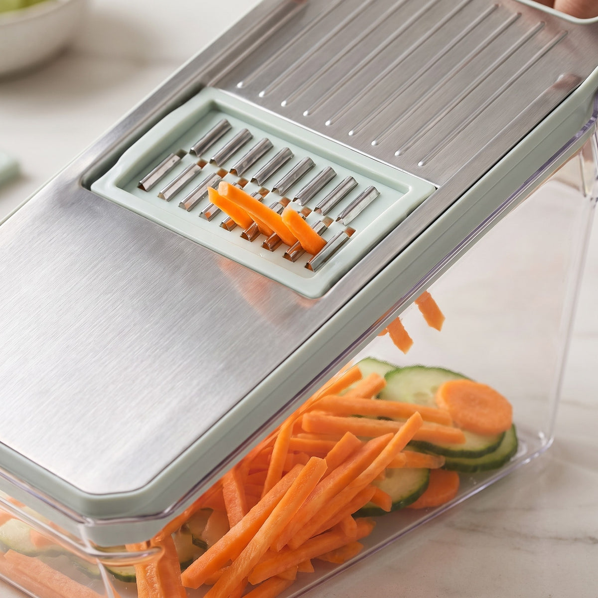 Multi-Blade Vegetable Slicer with Container - close-up of the stainless steel julienne blade over the clear container