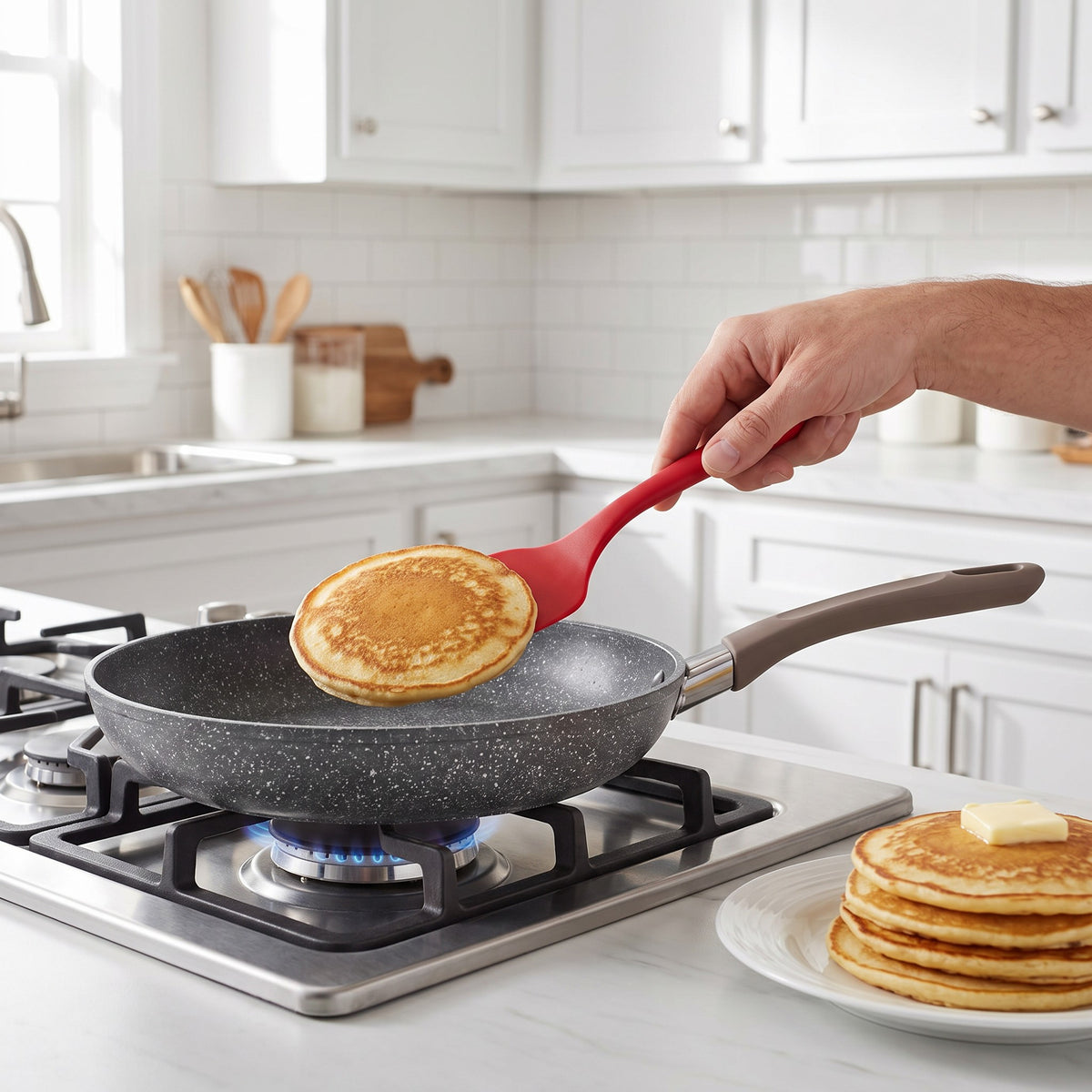 Non-Stick Stone-Effect Frying Pan with Raised Rim in use, flipping a pancake on a gas stovetop