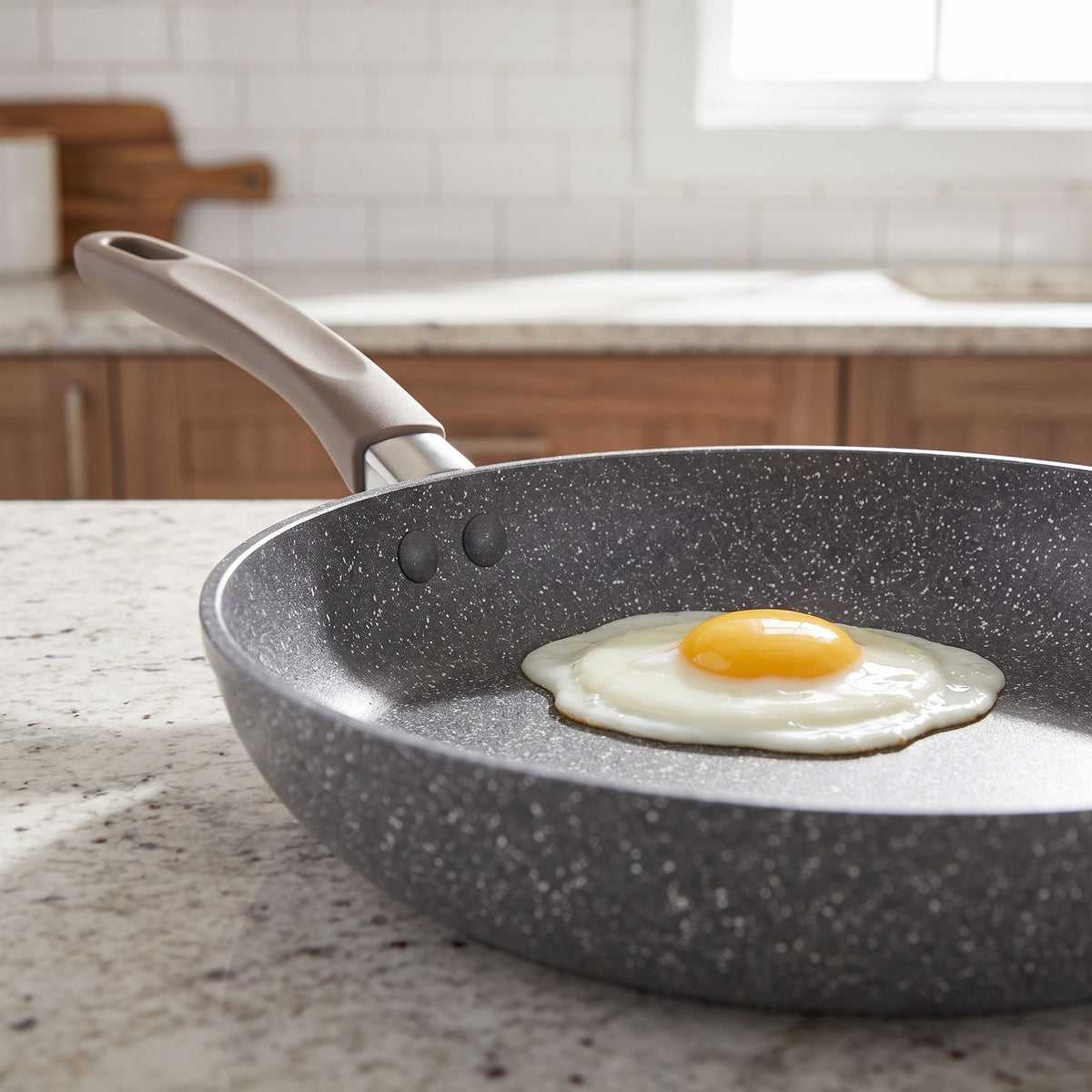Non-Stick Stone-Effect Frying Pan with Raised Rim - close-up of the speckled stone-effect non-stick coating with a fried egg