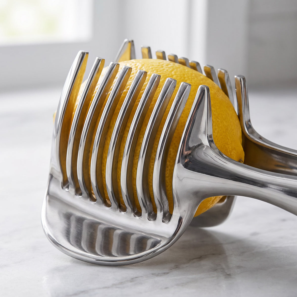 Parallel-Blade Tomato and Lemon Slicer with Food Holder - close-up of the parallel stainless steel blades holding a lemon