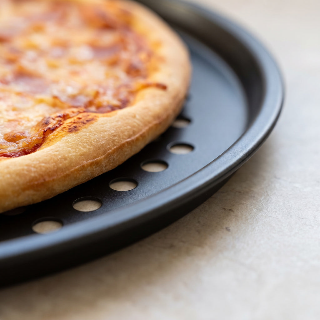 Perforated Non-Stick Carbon Steel Pizza Pan for Crisp Crusts - close-up of the perforated non-stick carbon steel rim under a baked crust