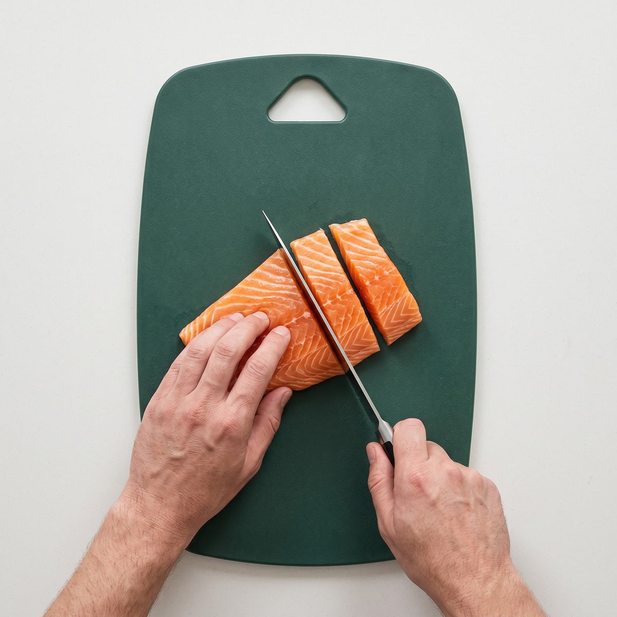 Plastic Cutting Board for Raw Meat Poultry and Fish in use, cutting a salmon fillet into portions