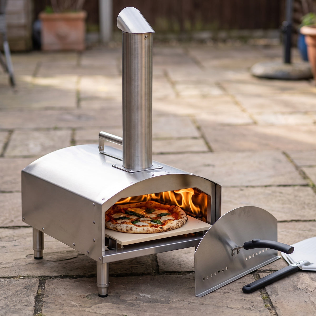 Portable Wood Pellet and Charcoal Pizza Oven with Stone and Peel - close-up of the 430 stainless steel body with a pizza baking on the stone