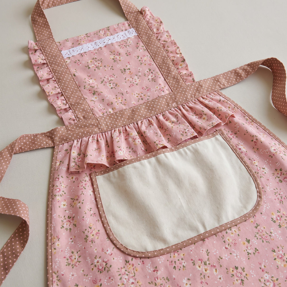 Retro Floral Ruffle Apron with Wide Shoulder Straps - close-up of the floral print, ruffled trim and pocket binding