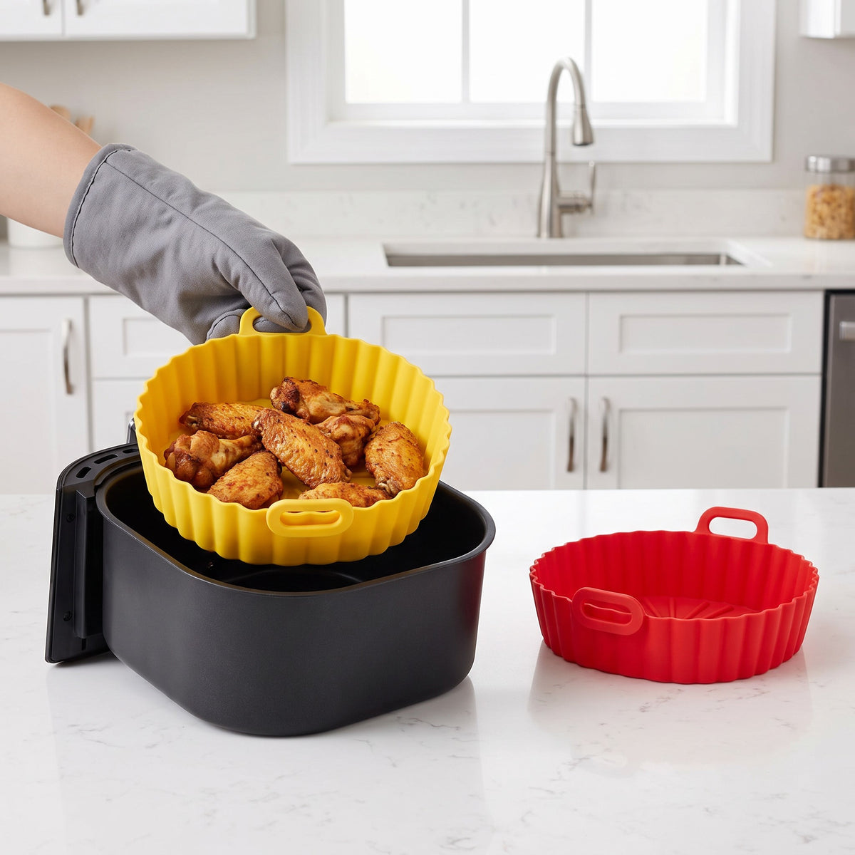 Reusable Silicone Air Fryer Liners Set of 2 with Handles in use, lifting crispy chicken wings out of an air fryer