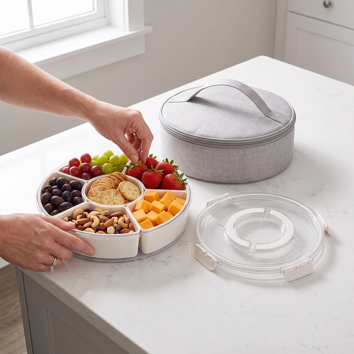 Rotating Divided Snack Serving Tray with Lid and Carry Bag in use, turning the tray to reach snacks on a kitchen island