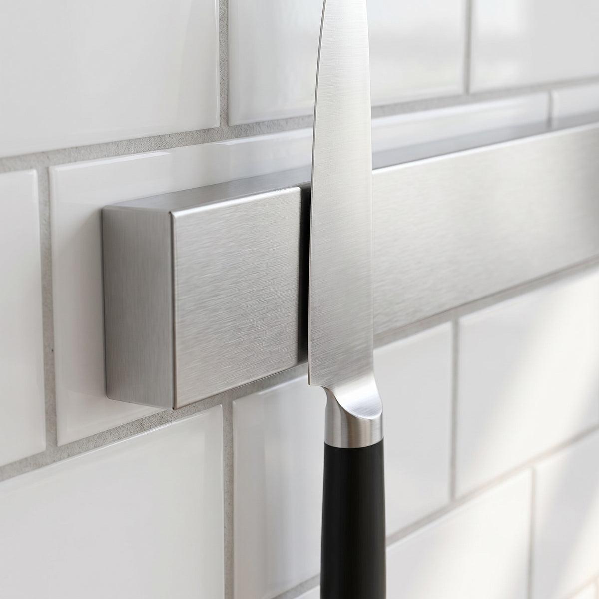 Stainless Steel Magnetic Knife Rack with No-Drill Adhesive Strips - close-up of the brushed stainless steel bar holding a chef knife