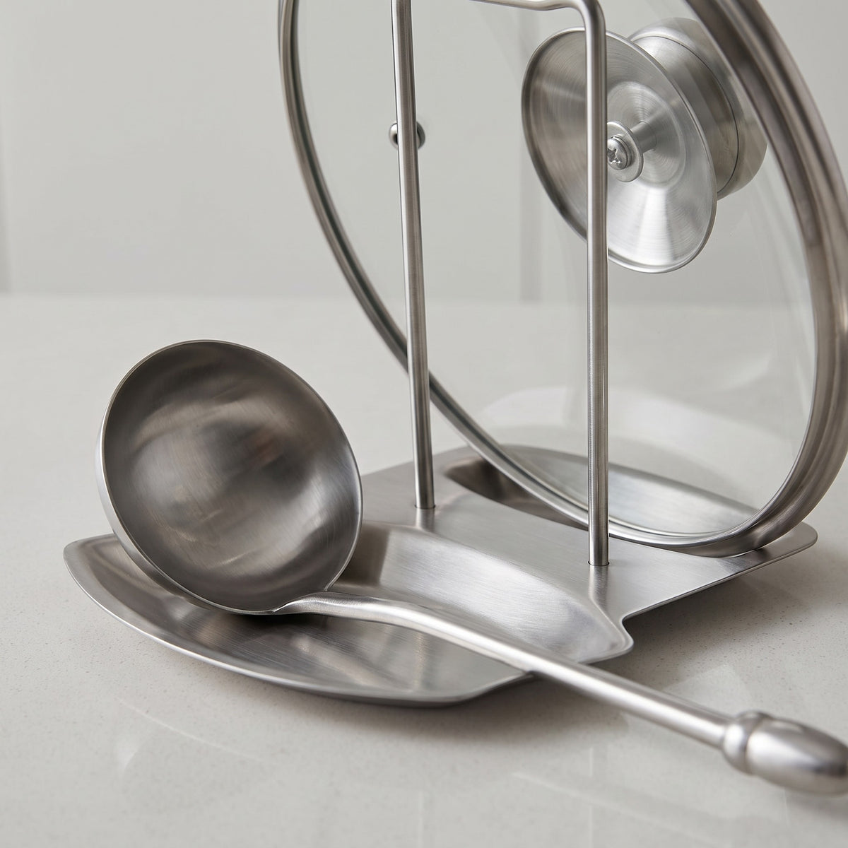 Stainless Steel Vertical Spoon Rest and Lid Holder - close-up of the brushed stainless steel base, ladle cradle and lid rods