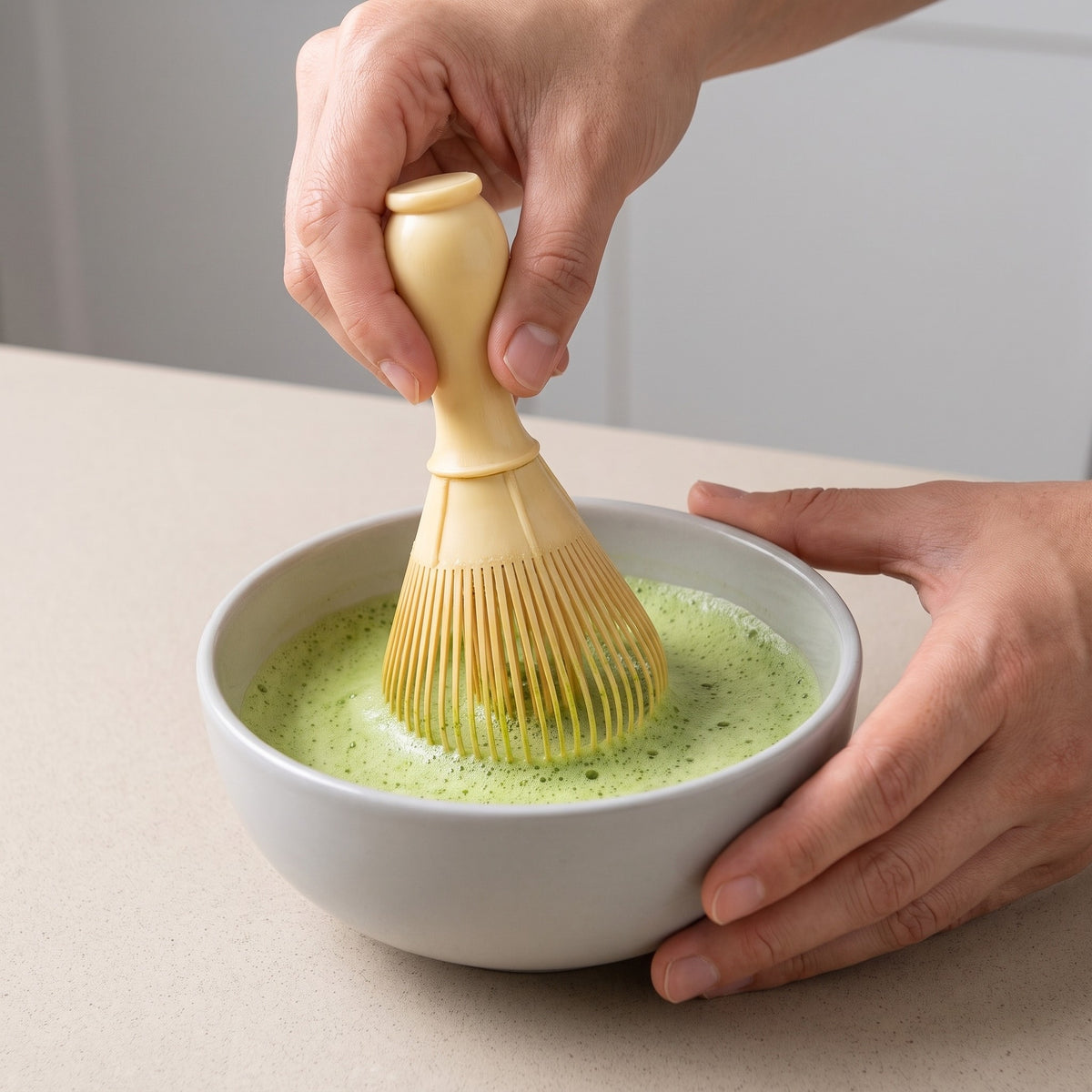 Traditional Bamboo Matcha Whisk for Frothy Tea in use, whisking matcha into a light foam