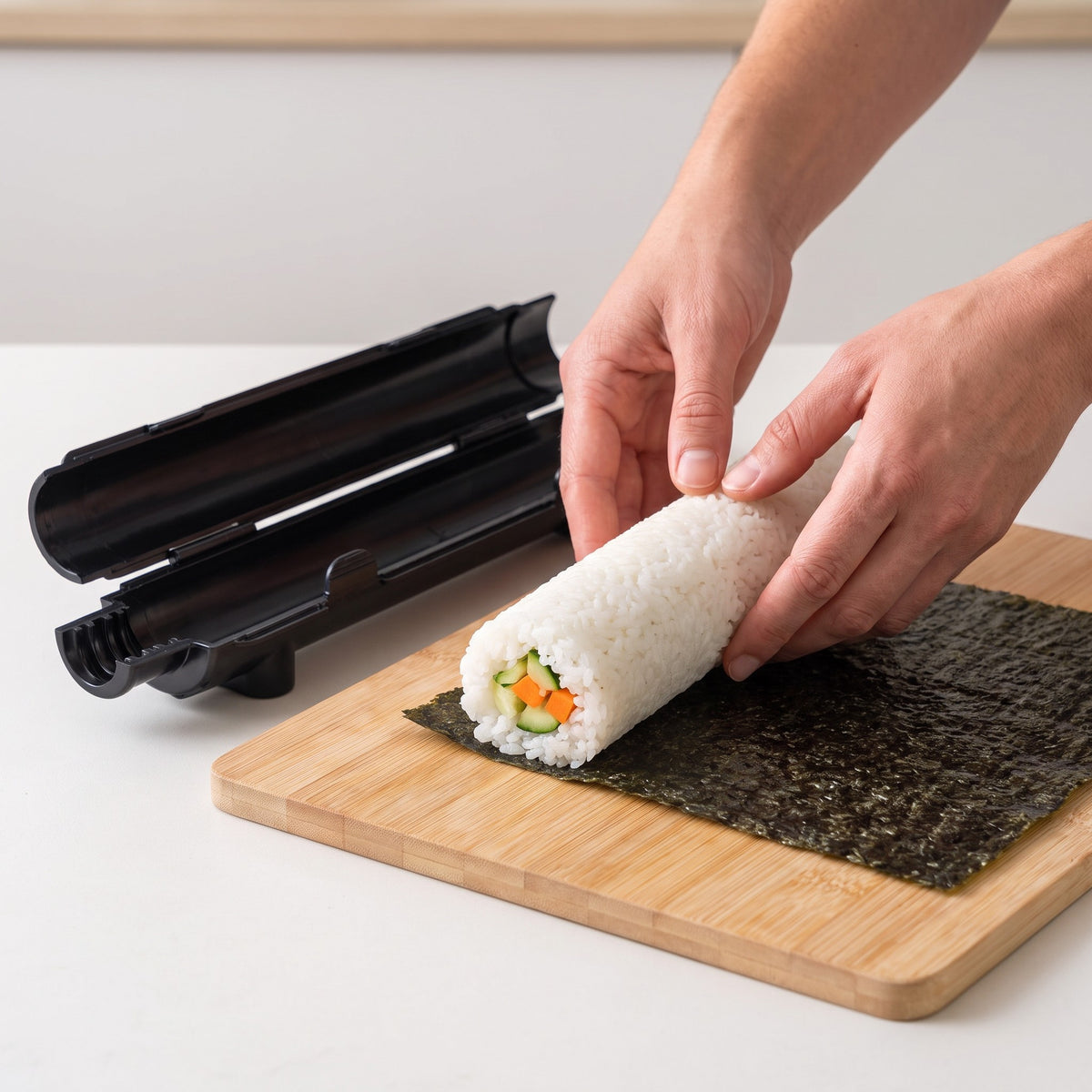 Tube-Style Sushi Bazooka Roll Maker for Maki and California Rolls in use, laying a rice roll onto a sheet of nori