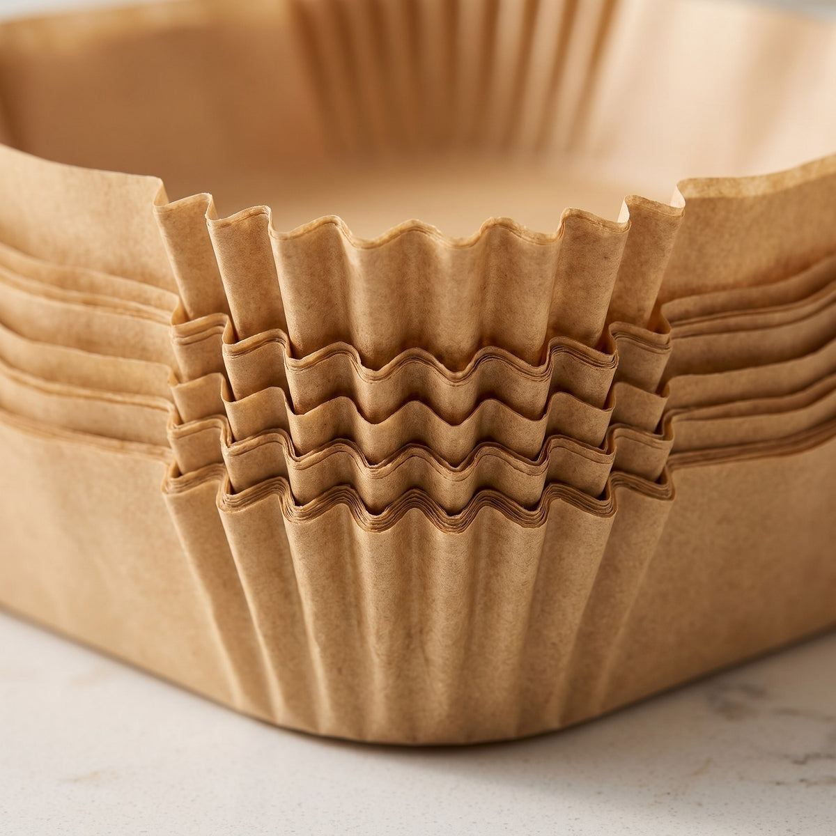Unbleached Air Fryer Parchment Paper Liners - close-up of the crimped edges of stacked unbleached liners