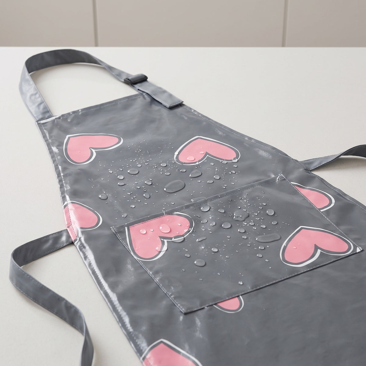 Waterproof Printed Kitchen Apron for Frying and Baking - close-up of the heart print and water beading on the waterproof fabric